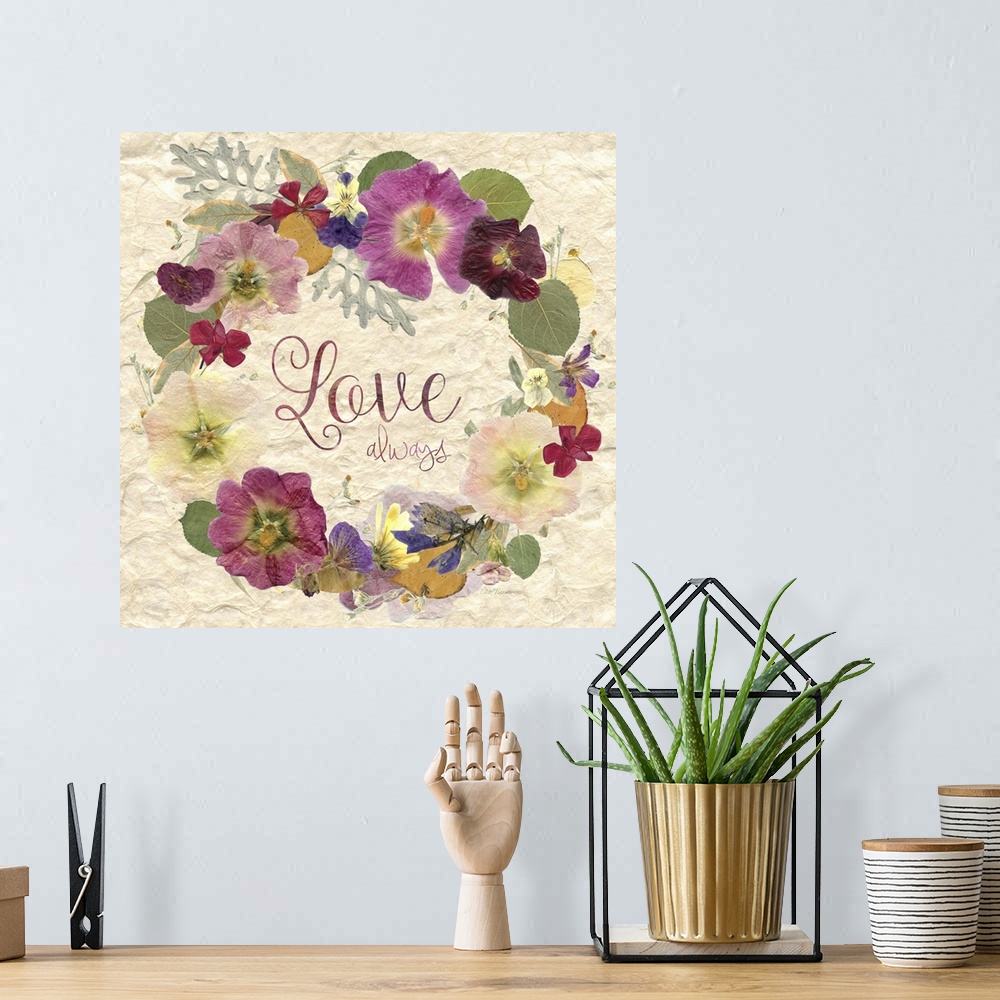 A bohemian room featuring Square art with a wreath made of dried and pressed flowers with the phrase "Love Always" written ...