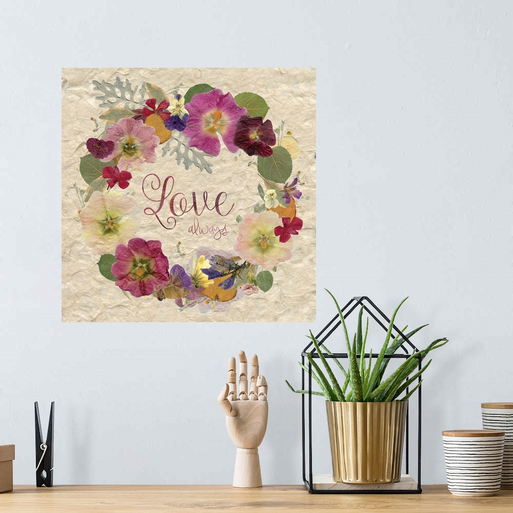 A bohemian room featuring The word "love" in a wreath made of dried, pressed flowers.