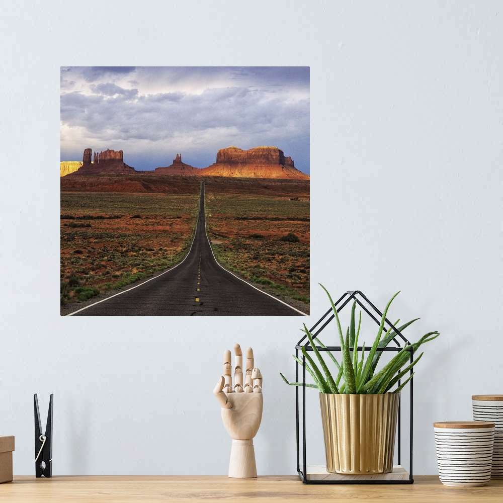 A bohemian room featuring A road leading towards the tall rock formations in Monument Valley, Arizona.