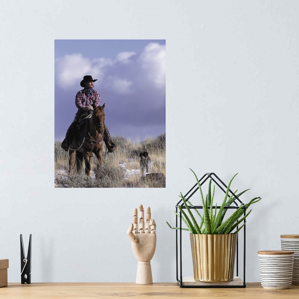 A bohemian room featuring A cowboy poses on his horse with his dog