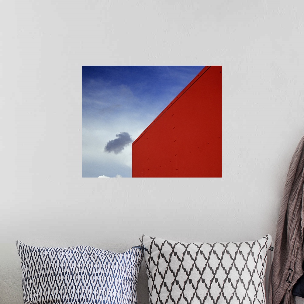 A bohemian room featuring A shadowed cloud floating through blue sky over the red corner of James John School.