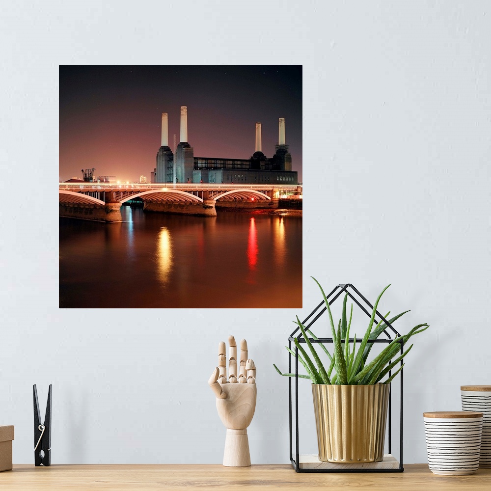 A bohemian room featuring Battersea Power Station at night with light reflections in river Thames.