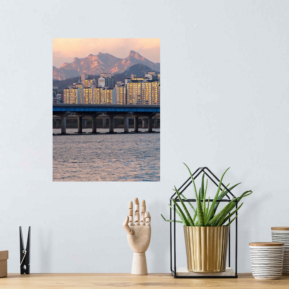 A bohemian room featuring Buildings and Mount Bukhan by Han river in Seoul, South Korea.