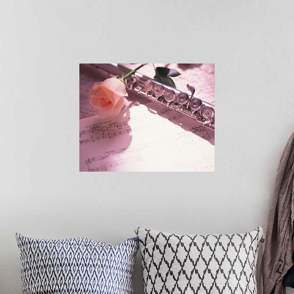 A bohemian room featuring Flute next to sheet music and pink rose