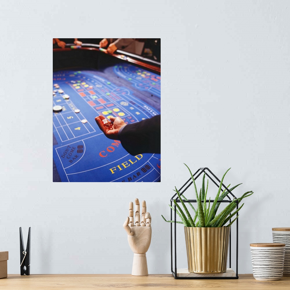A bohemian room featuring Man shaking dice during game of craps in casino
