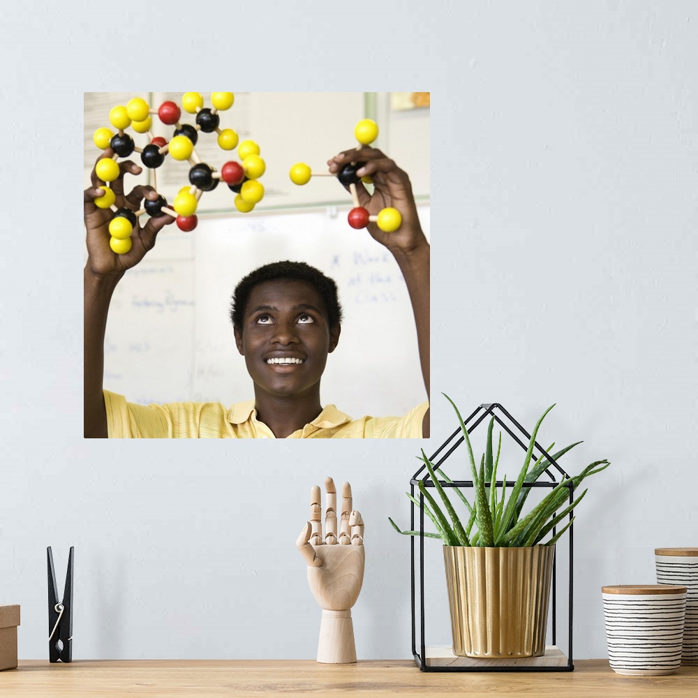 A bohemian room featuring African teenage boy viewing molecule model