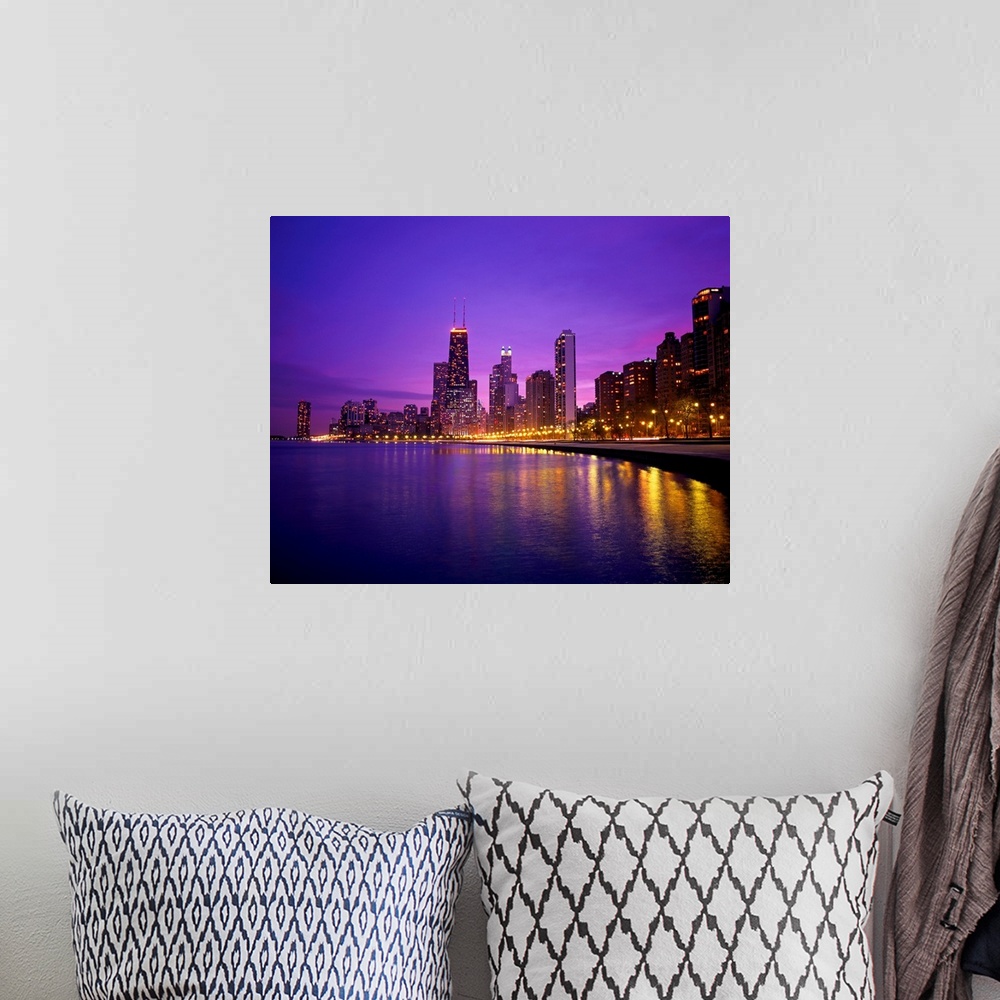 A bohemian room featuring Photograph of cityscape and waterfront at night.  The buildings are lit up and the lights are ref...