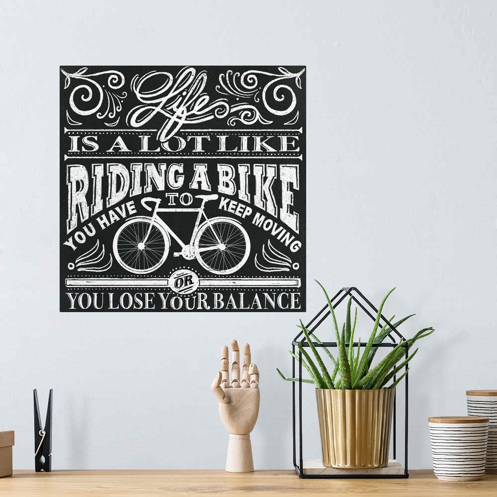 A bohemian room featuring Typography artwork in a chalkboard style reading "Life is a lot like riding a bike, you have to k...