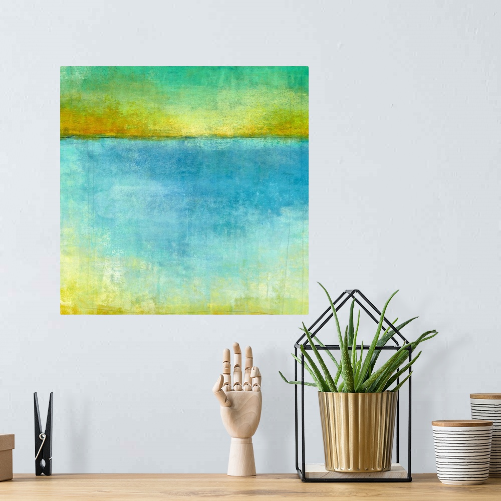 A bohemian room featuring Abstract artwork resembling a lake and horizon in blue, yellow, and green shades.