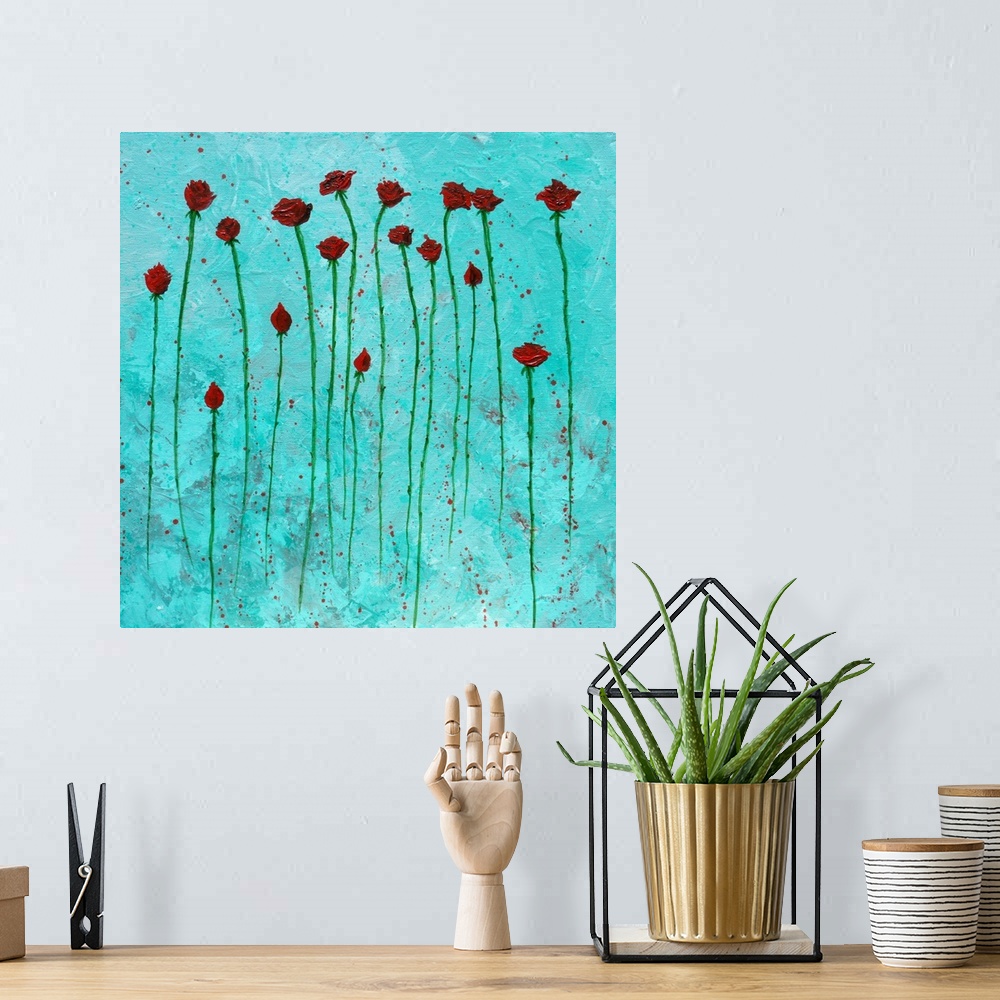 A bohemian room featuring Square painting of red roses with long green stems on an aqua background with red paint splatter.