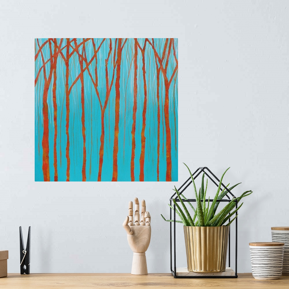 A bohemian room featuring Simple landscape painting with bare orange tree trunks and branches on a bright blue background.