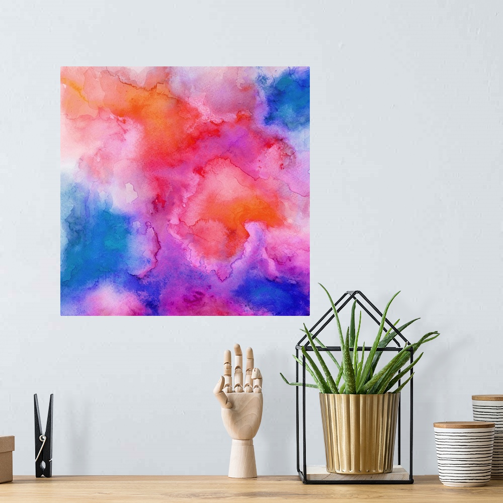 A bohemian room featuring A square abstract watercolor painting in brilliant colors of pink, orange and blue.