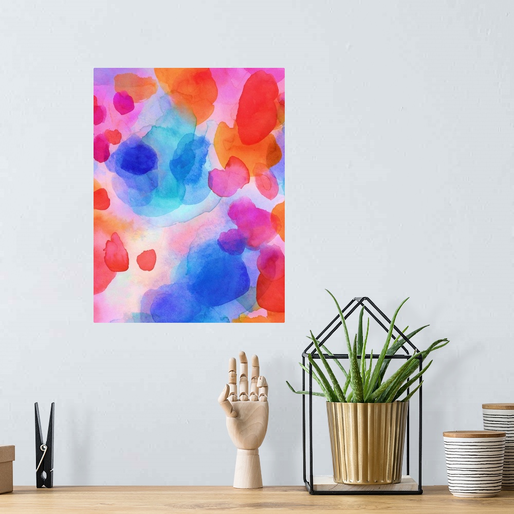 A bohemian room featuring A vertical abstract watercolor painting in brilliant colors of pink, orange and blue.