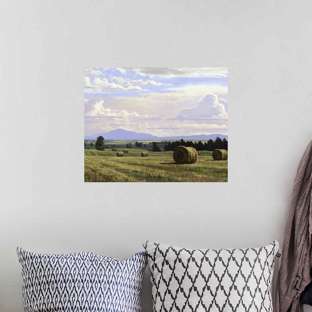 A bohemian room featuring A contemporary landscape painting of freshly cut hay bails sitting in a countryside field.