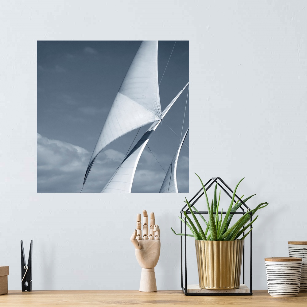 A bohemian room featuring Black and white photograph of three sails against a cloudy sky.