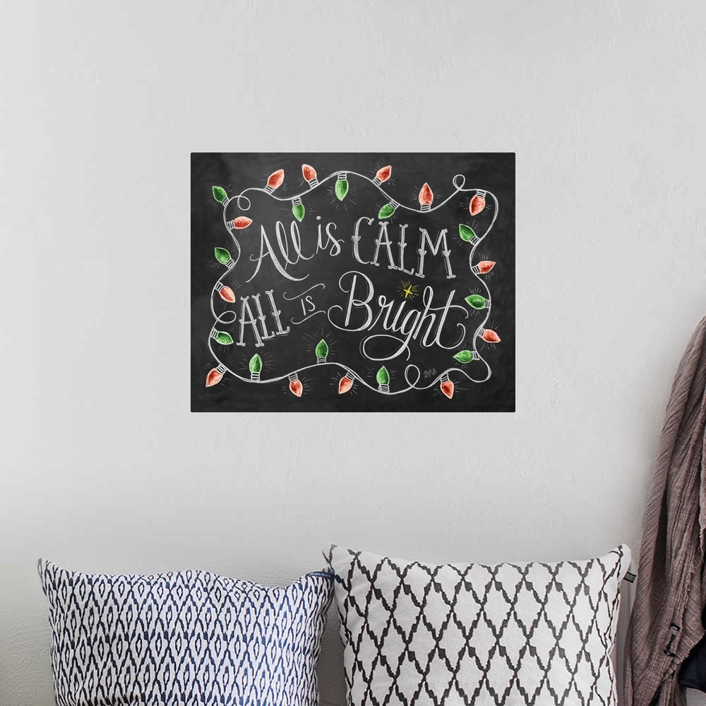 A bohemian room featuring "All is calm, all is bright" handwritten in chalk with Christmas lights around it.