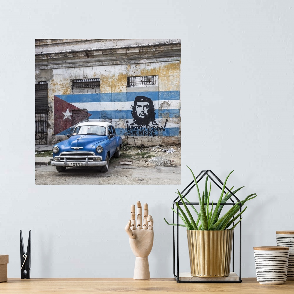 A bohemian room featuring Classic American car and Cuban flag, Habana Vieja, Havana, Cuba.