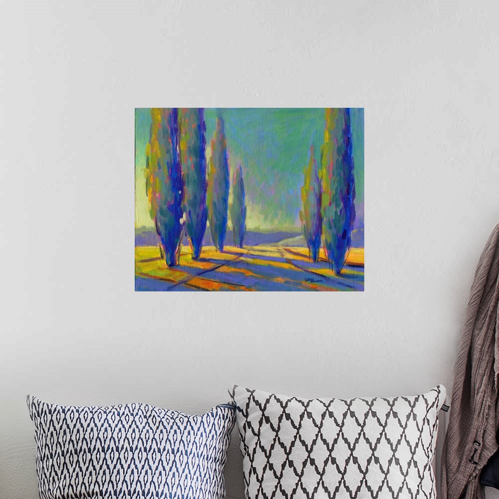 A bohemian room featuring Contemporary painting of tall, skinny trees in a field with pink and yellow sunset colors shining...