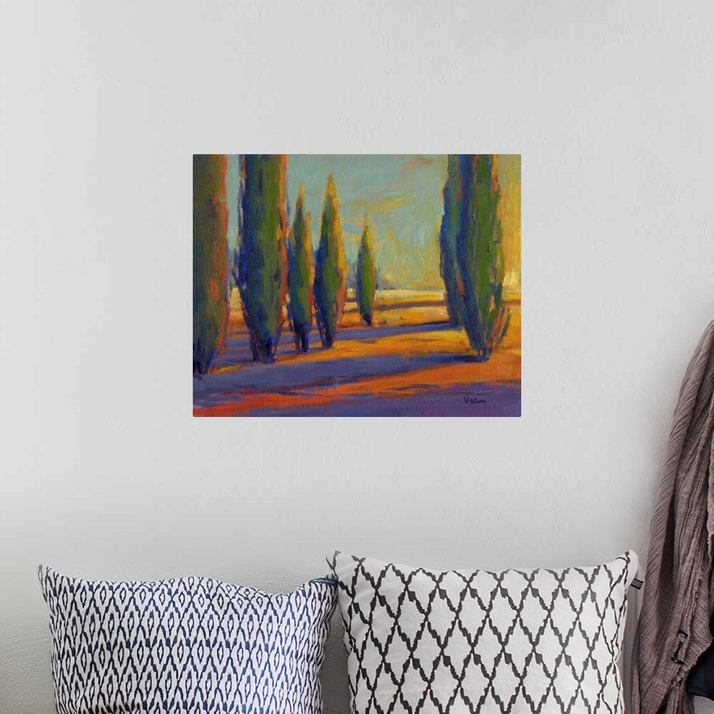 A bohemian room featuring A contemporary painting of a divide between a row of cypress trees in golden colors.