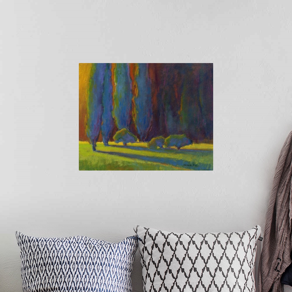 A bohemian room featuring Horizontal painting of a row of trees in shades of blue, orange and green.