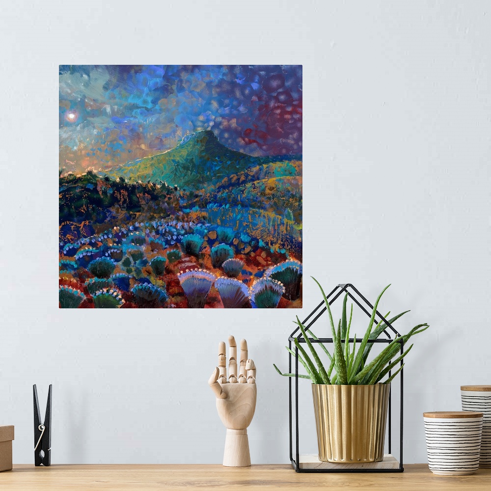 A bohemian room featuring Brightly colored contemporary artwork of a colorful landscape of cacti.