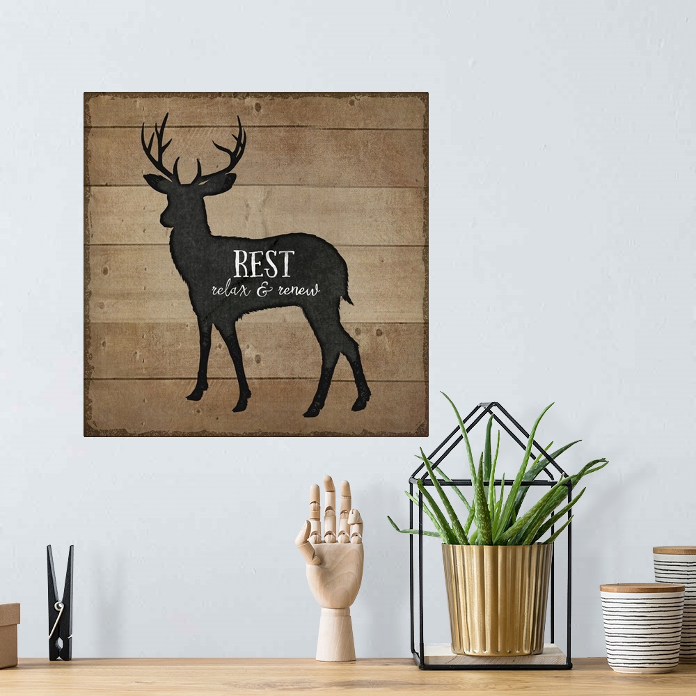 A bohemian room featuring Cabin decor of a deer silhouette on a wooden board background.