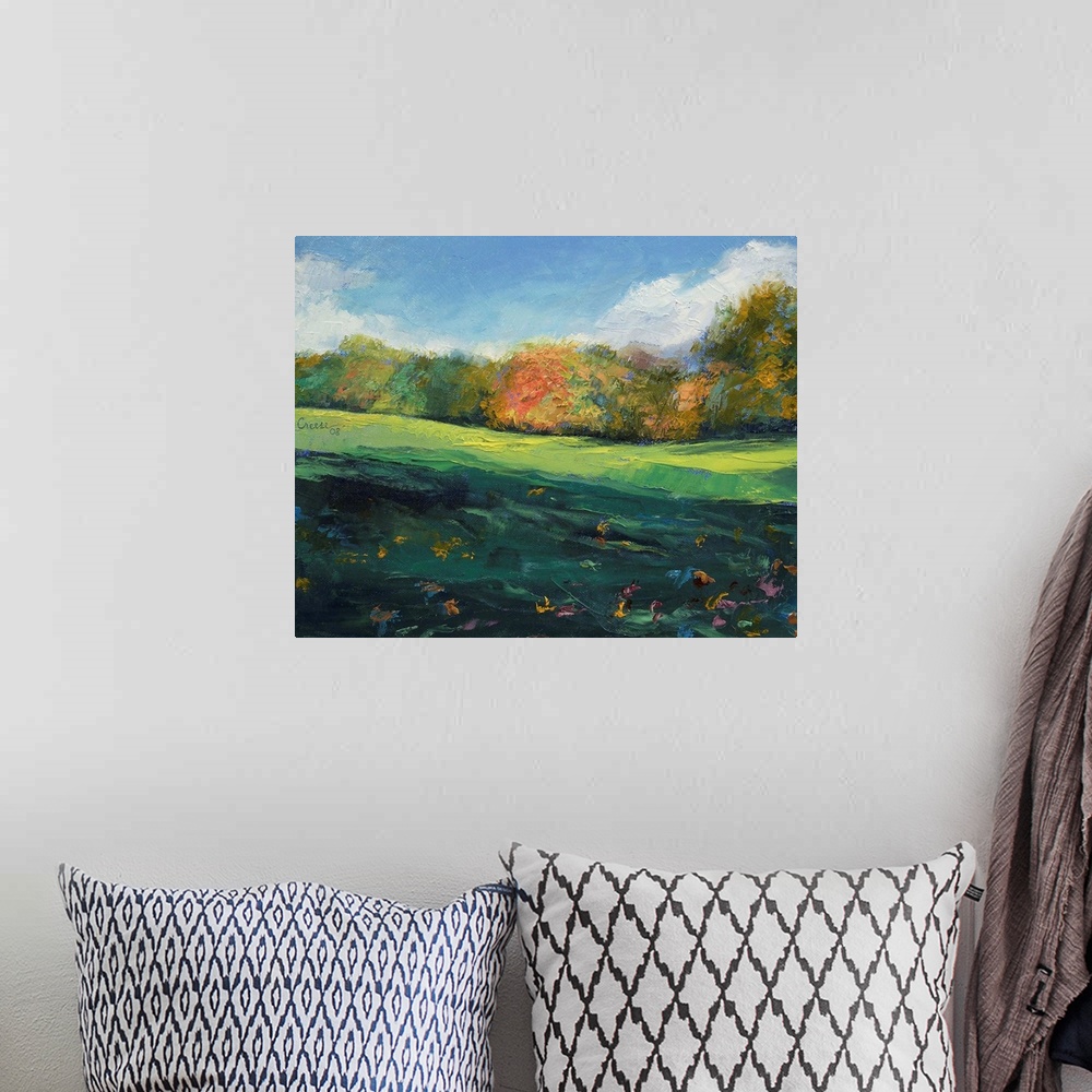 A bohemian room featuring Landscape painting on a large wall hanging of a rolling, green landscape with autumn colored tree...