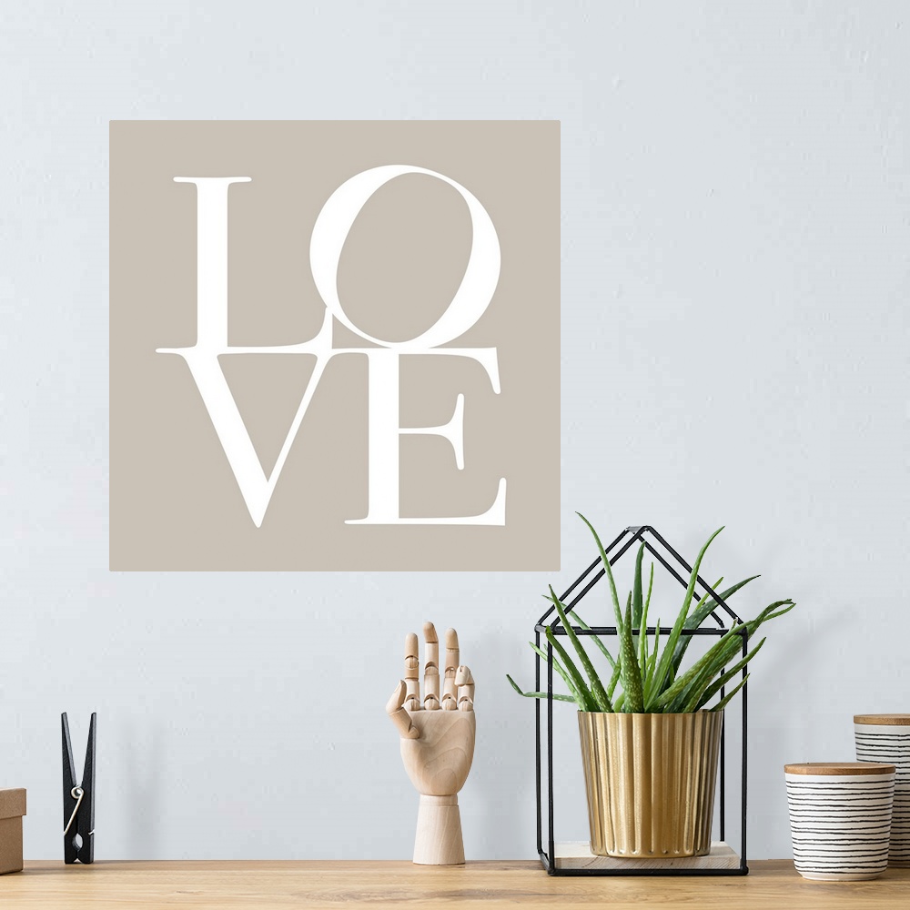A bohemian room featuring LOVE, typography text art print and canvas print, with the word LOVE written against a taupe / be...