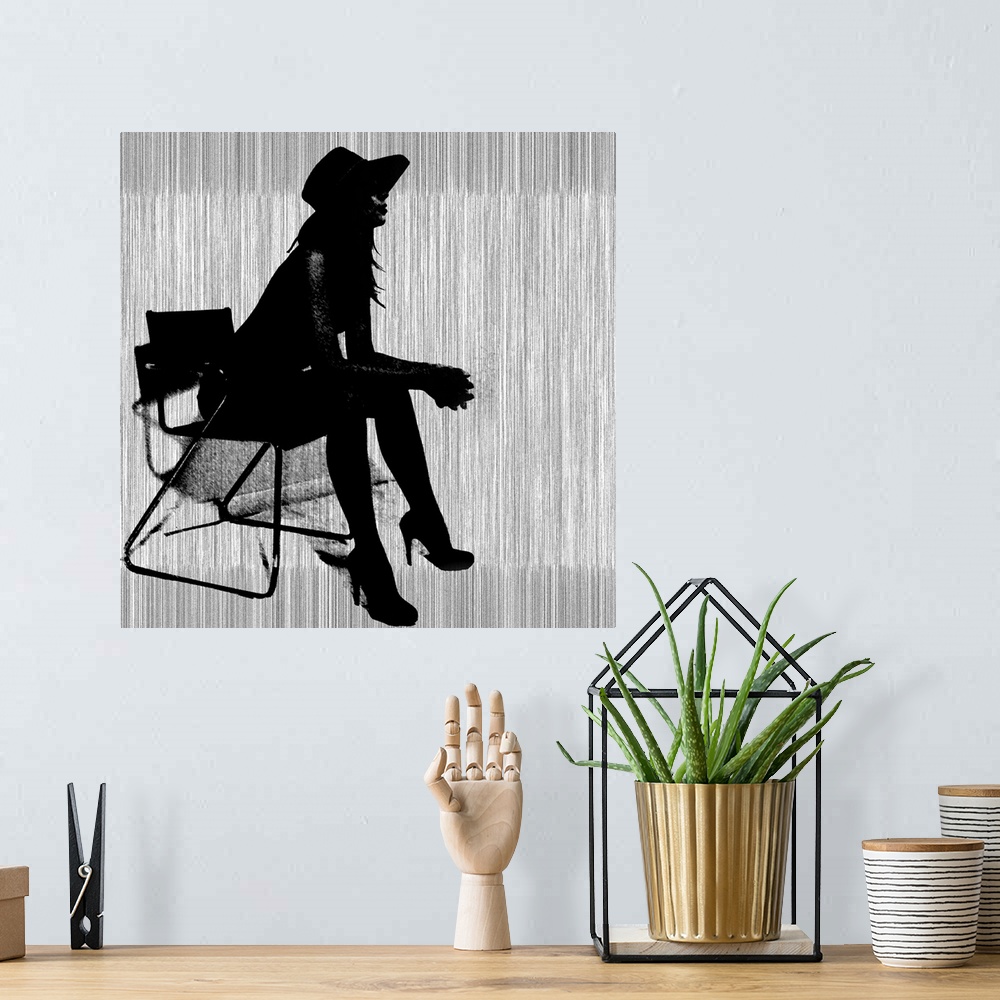 A bohemian room featuring Contemporary artwork of a silhouette of a woman wearing hills and a hat leaning forward in a chai...