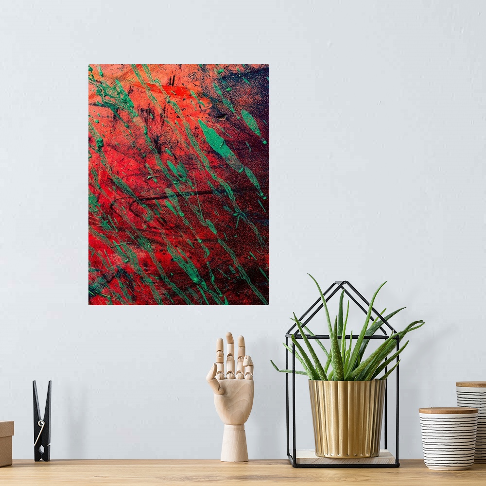 A bohemian room featuring Textured art with a bright red background with black and green strokes of color.