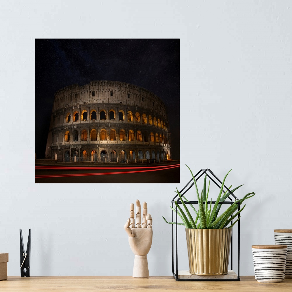 A bohemian room featuring The Colosseum in Rome illuminated at night with light trails from passing cars.