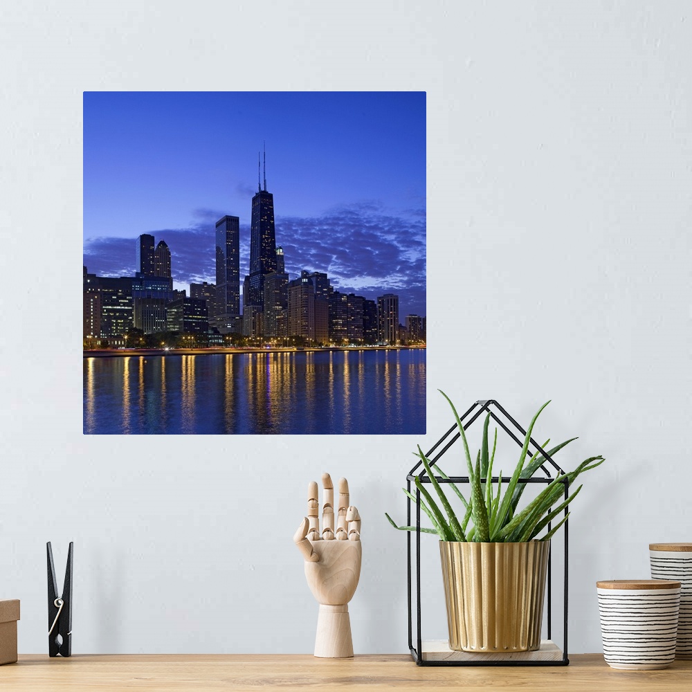 A bohemian room featuring Big, square photograph of the Chicago skyline at night, reflecting in the waters of Lake Michigan.