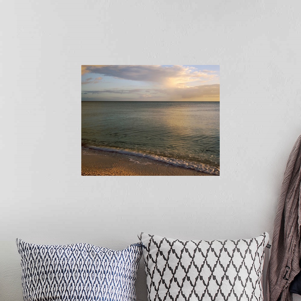 A bohemian room featuring Giant photograph shows the calm waters of a coastline as they gently crash against the sandy shor...