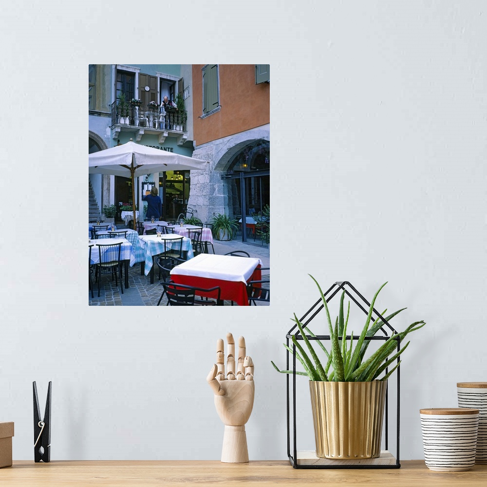 A bohemian room featuring Vertical panoramic photograph outside eatery next to street shops at dusk.