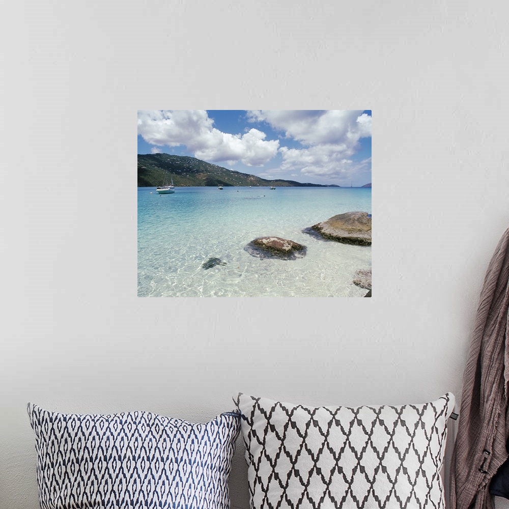 A bohemian room featuring Big photo print of boats floating near the shore of a clear ocean with hills in the background.
