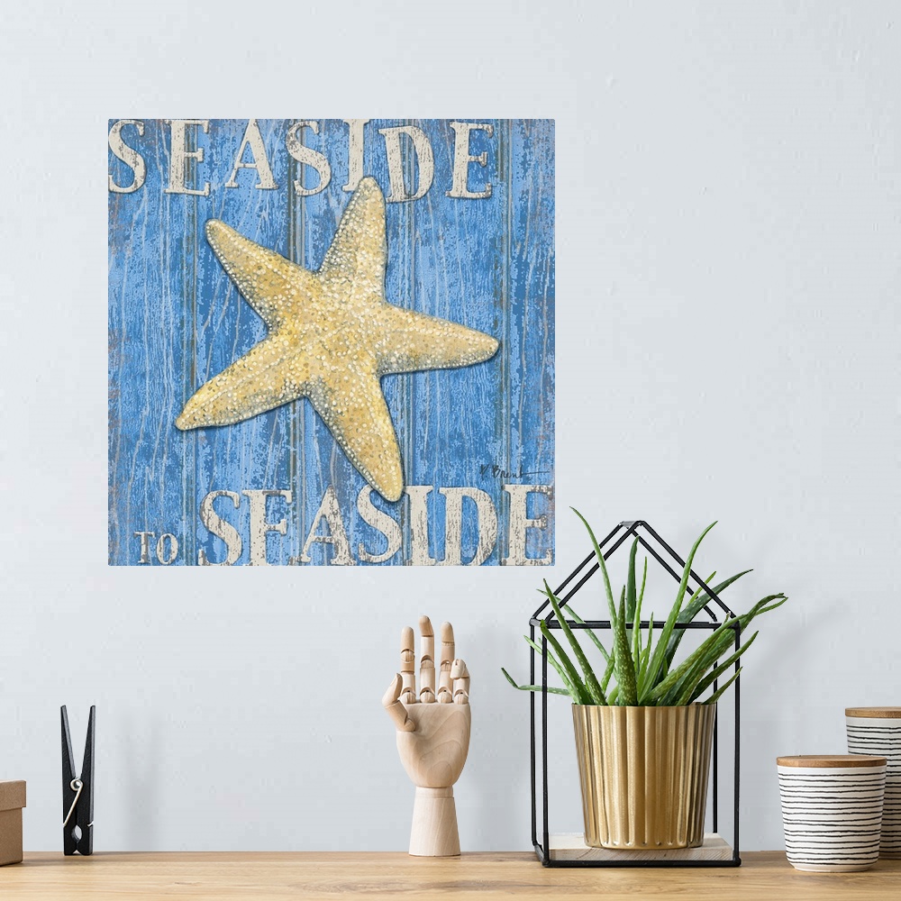 A bohemian room featuring Square painting of a starfish on blue wood panels with the text Seaside to Seaside.