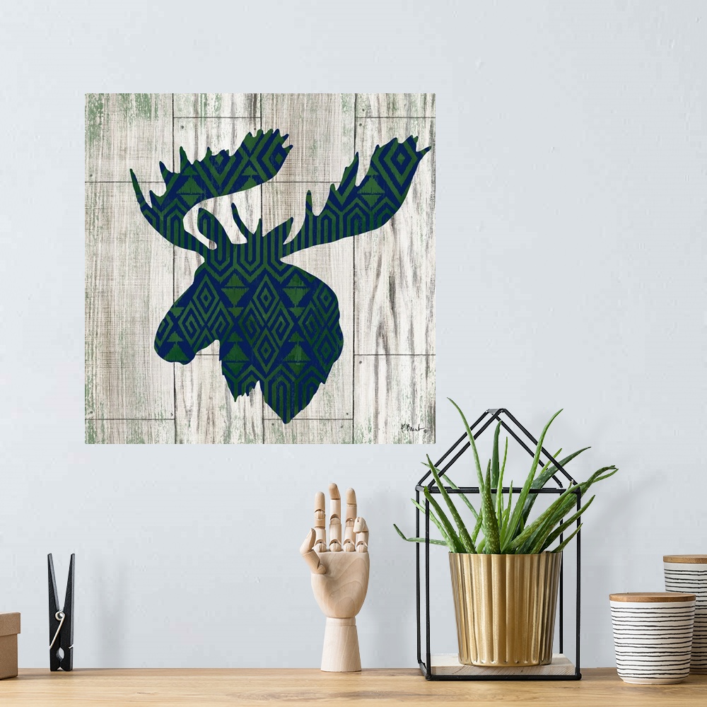 A bohemian room featuring Square cabin decor with a blue and green patterned silhouette of a moose on a faux distressed woo...