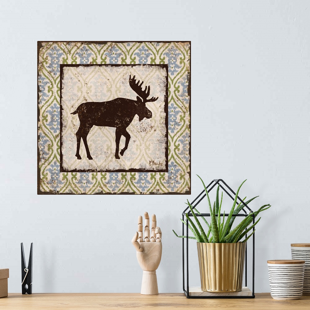 A bohemian room featuring Decorative square artwork featuring a silhouetted moose on a boho pattern.