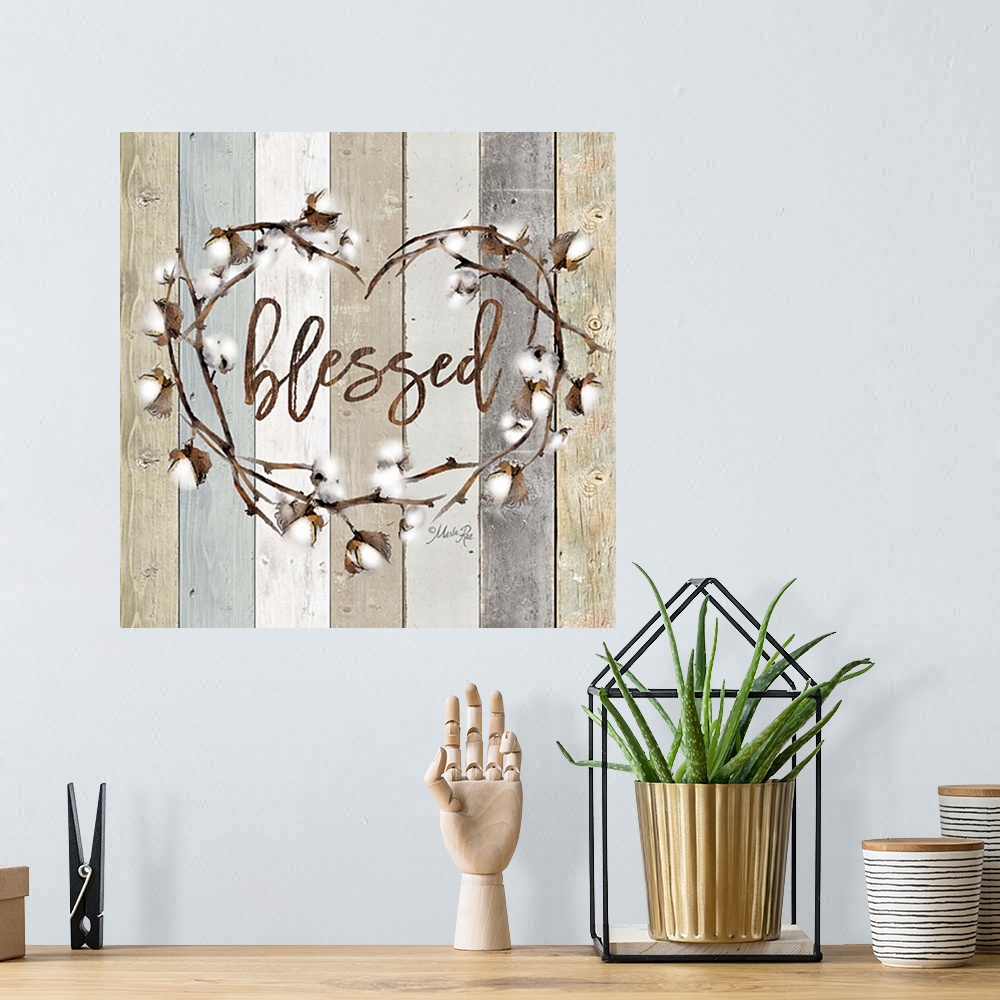 A bohemian room featuring "Blessed" in the middle of a heart wreath of cotton against a shiplap background.