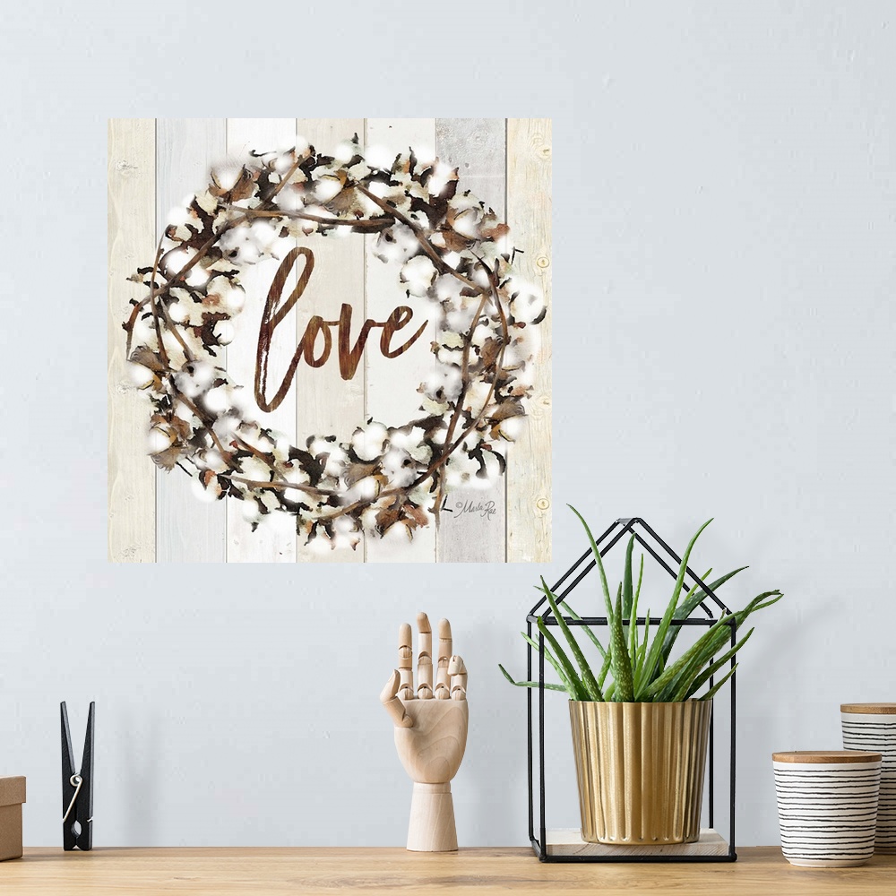 A bohemian room featuring "Love" in the middle of a wreath of cotton against a shiplap background.