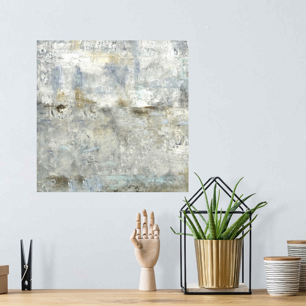 A bohemian room featuring Square abstract painting with cool gray, blue, and gold tones.