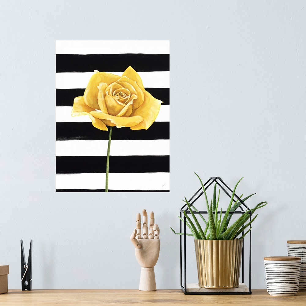 A bohemian room featuring A single yellow rose over a black and white striped background.