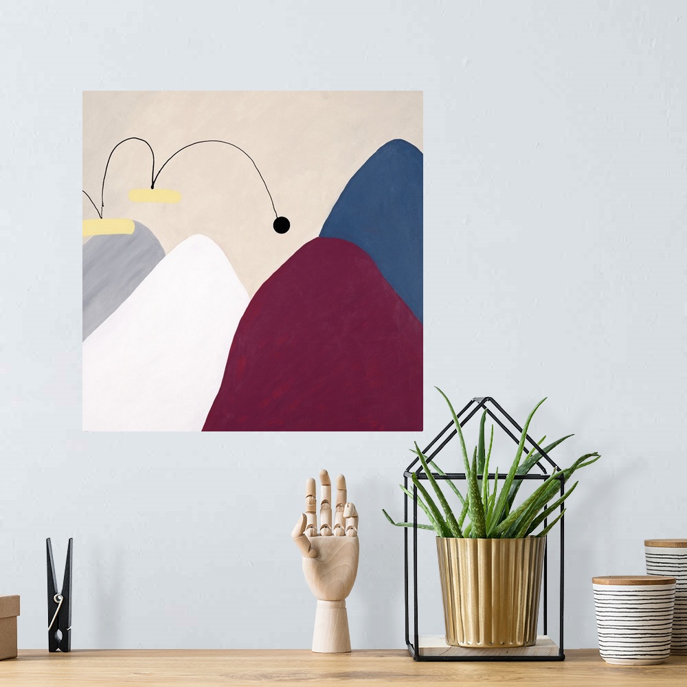 A bohemian room featuring Contemporary abstract art of several mountains, each different in color, with a small ball that a...