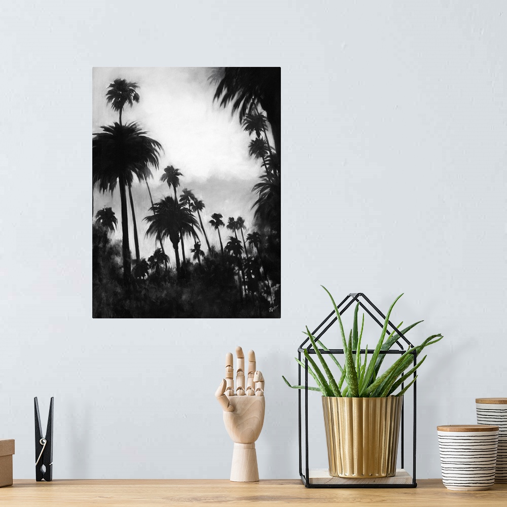 A bohemian room featuring A black and white contemporary painting of a tree line of palm trees against of cloudy sky.