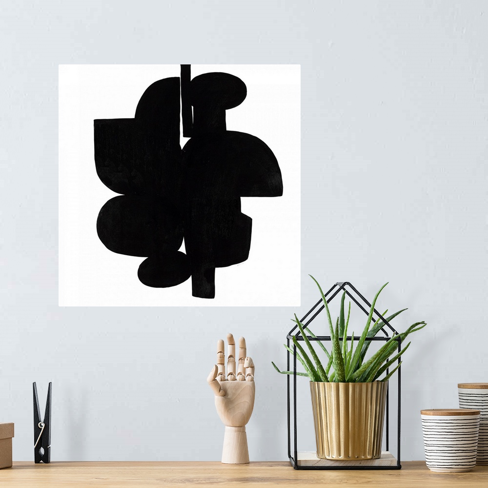 A bohemian room featuring Square art that has dark black shapes connecting on a white background with a minimalist feel.