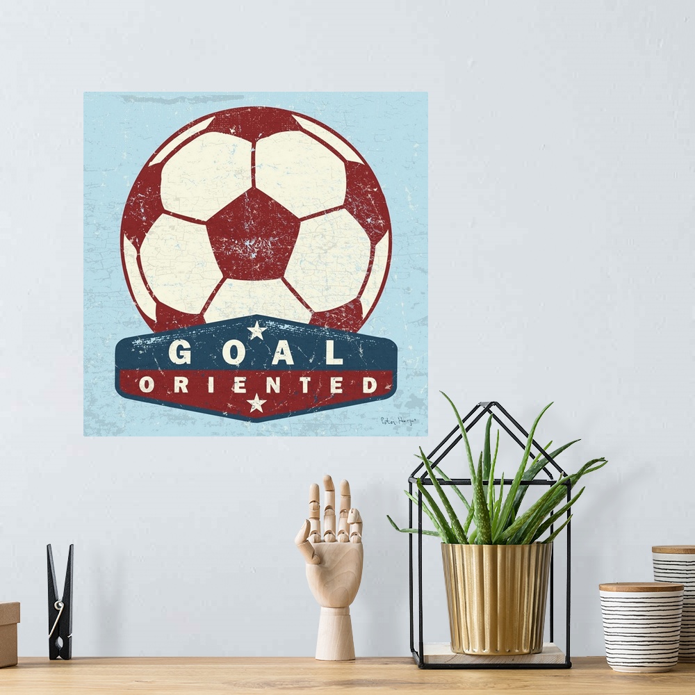A bohemian room featuring Distressed  large red soccer ball with a typography saying Goal Oriented.