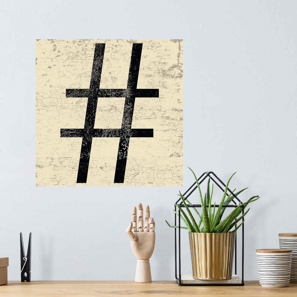 A bohemian room featuring Distressed typography wall art of a large black hashtag character on a tan and sepia background.