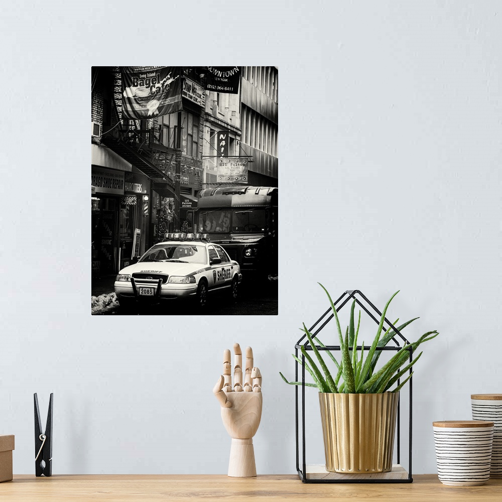 A bohemian room featuring A black and white photograph of an NYPD police car in New York city.