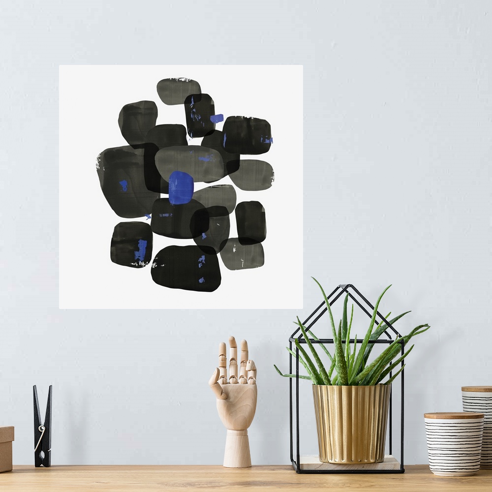 A bohemian room featuring Abstract painting of shapes of black with blue accents.