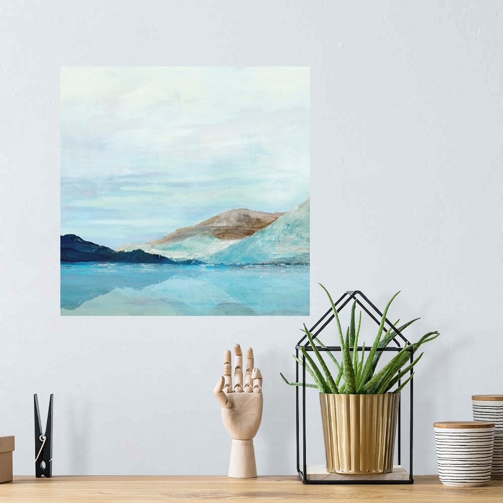 A bohemian room featuring Square painting of rolling mountains along a lake with a clear blue sky.